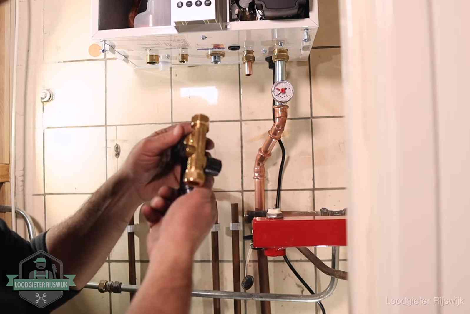 Vulkraan en manometer onder een cv-ketel voor het bijvullen van de waterdruk in Rijswijk