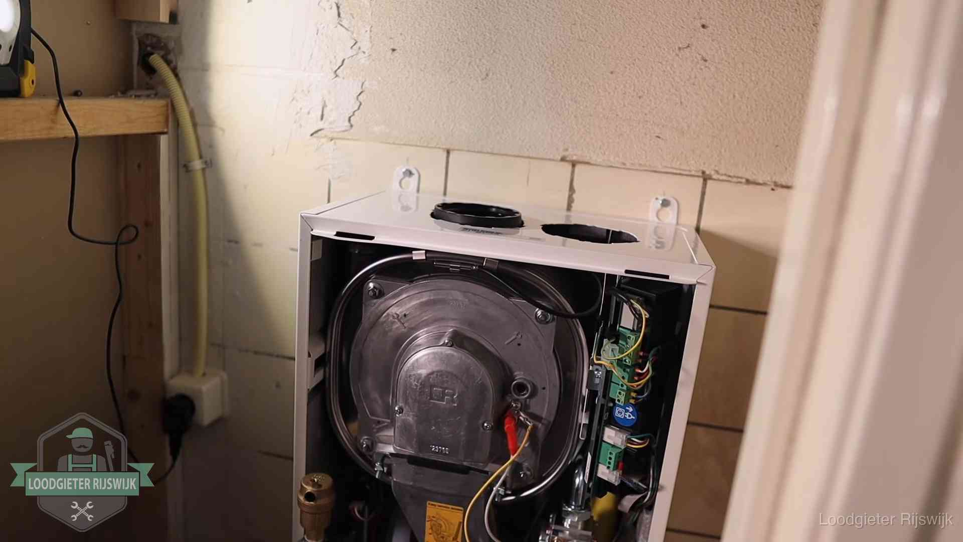 Geopende cv-ketel tijdens een onderhoudsbeurt in Rijswijk, met brander en warmtewisselaar zichtbaar