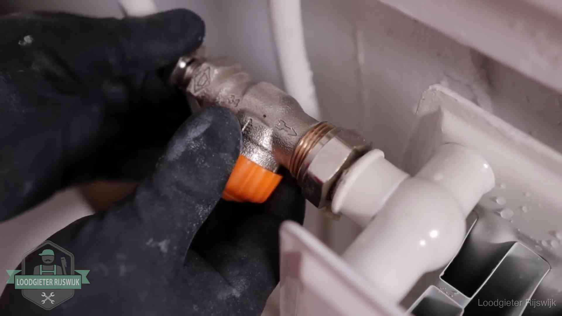 Thermostaatkraan wordt gemonteerd op een radiator in Rijswijk voor het stookseizoen