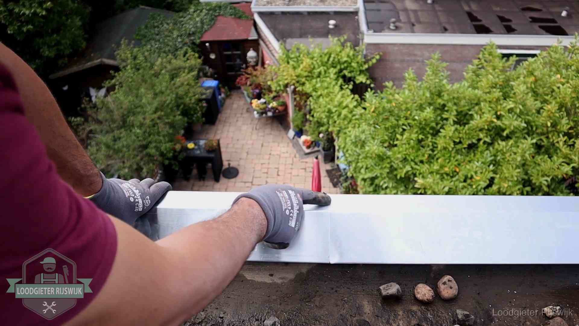 Daklekkage geregeld in Rijswijk Vakman plaatst een daktrim op de dakrand van een woning in Rijswijk