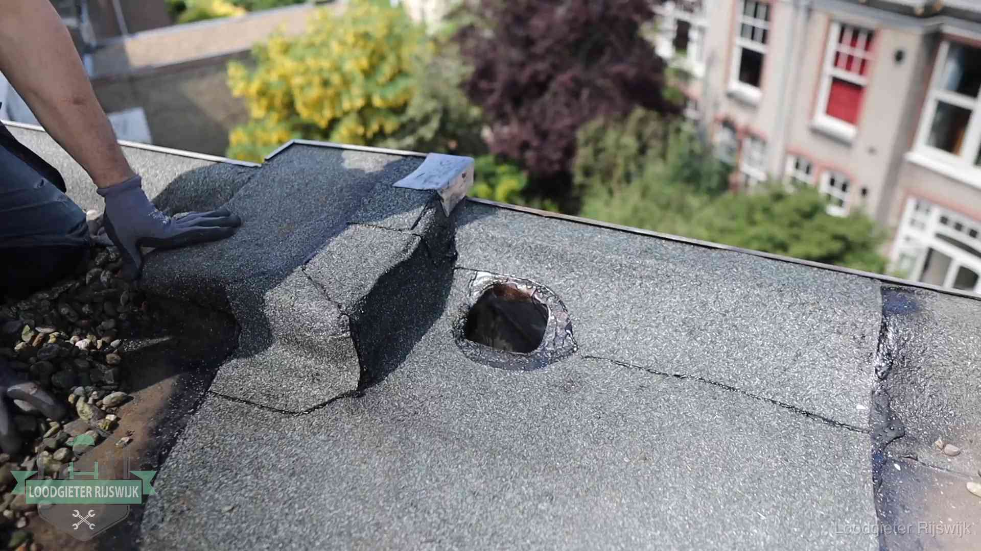 Daklekkage-inspectie op een plat dak in Rijswijk Loodgieter inspecteert een beschadigd bitumen plat dak tijdens een daklekkage-inspectie in Rijswijk