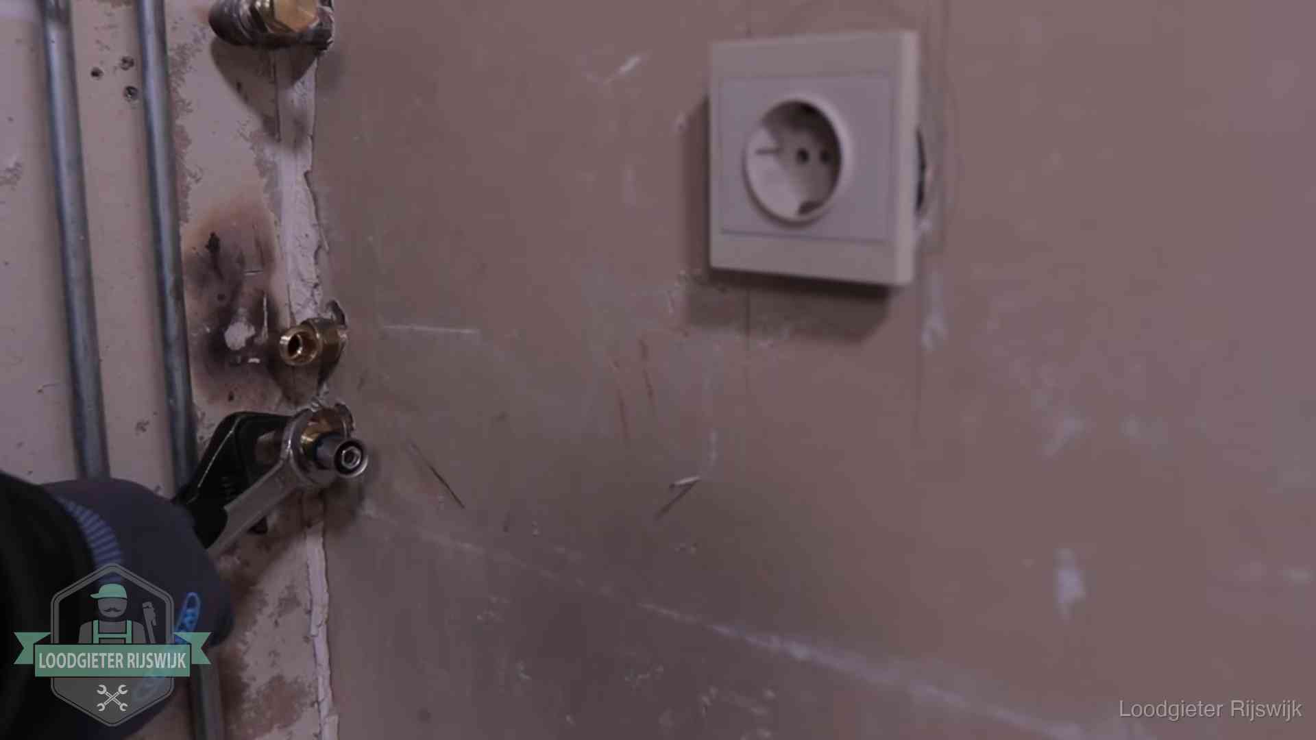 Monteur draait een perskoppeling vast op een leidingaansluiting in Rijswijk