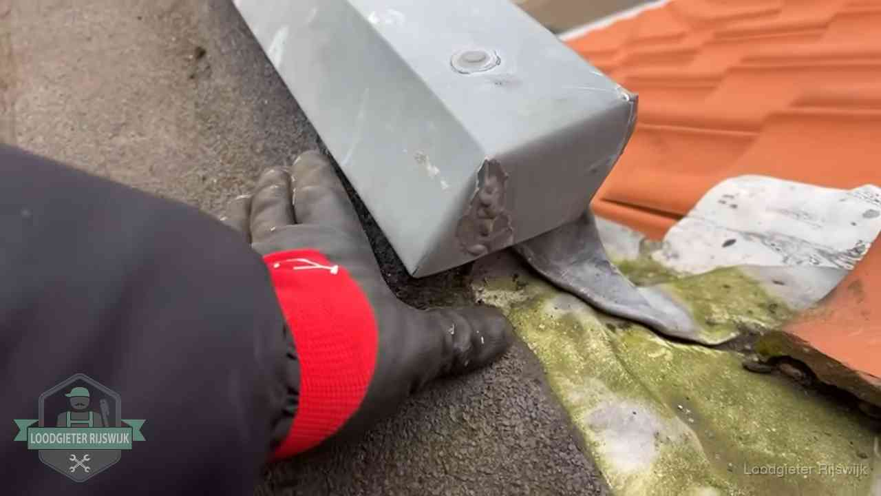 Hemelwaterafvoer en dakgoot controleren in Rijswijk Controle van een zinken hemelwaterafvoer met loodslab bij dakpannen in Rijswijk