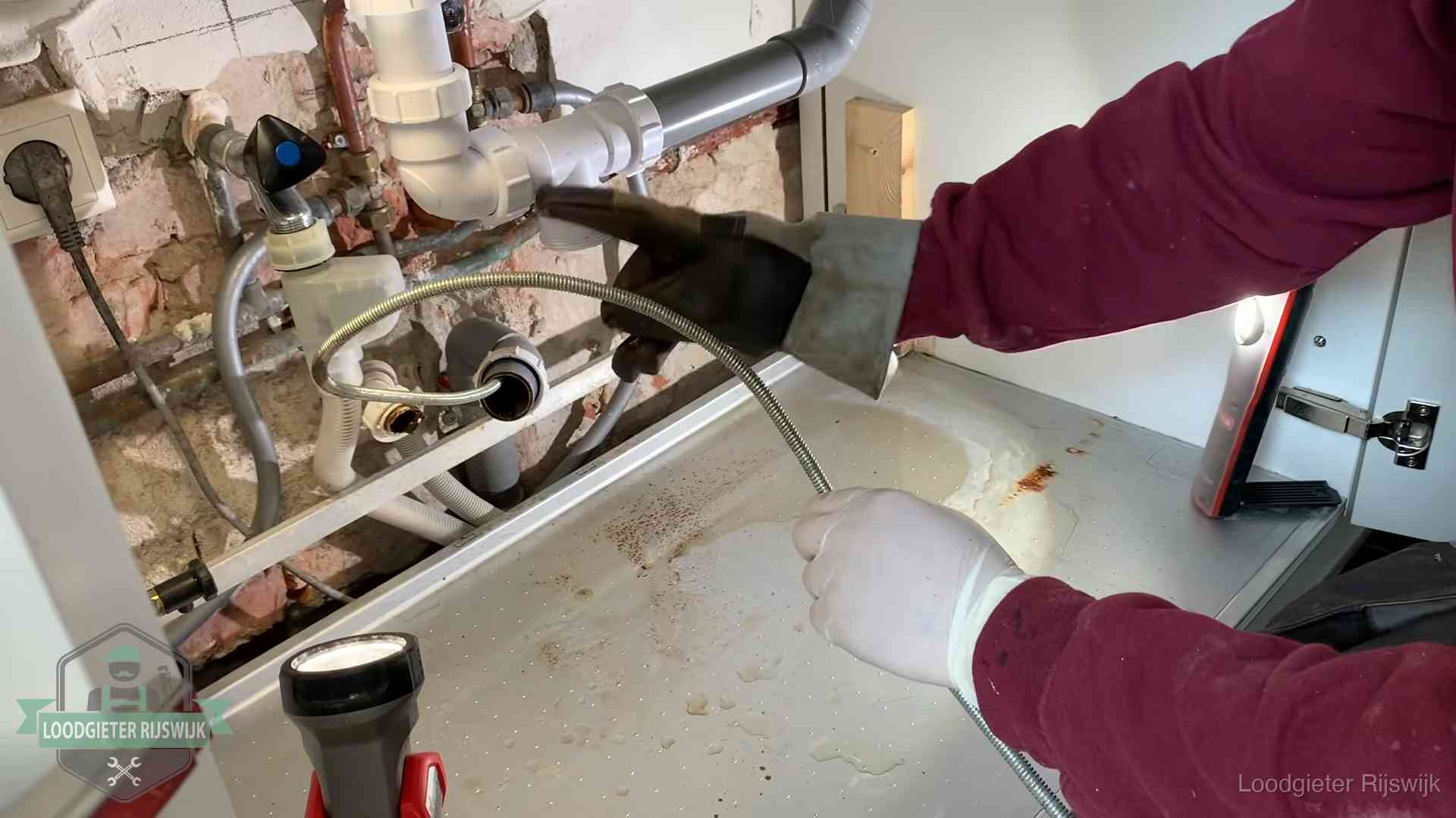 Spiraal of hogedruk in Rijswijk Ontstoppingsveer gaat in een geopende sifonaansluiting onder het aanrecht in Rijswijk