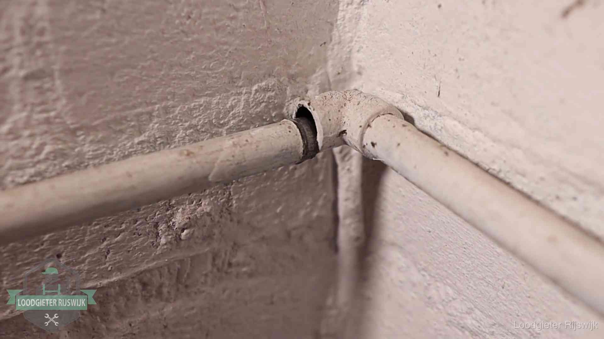 Oude geverfde waterleiding met een losliggende fitting in een woning in Rijswijk