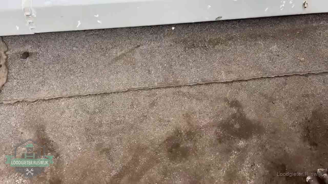 Stormschade en neerslag op daken in Rijswijk Vochtplekken bij de naad van een plat dak na aanhoudende regen in Rijswijk