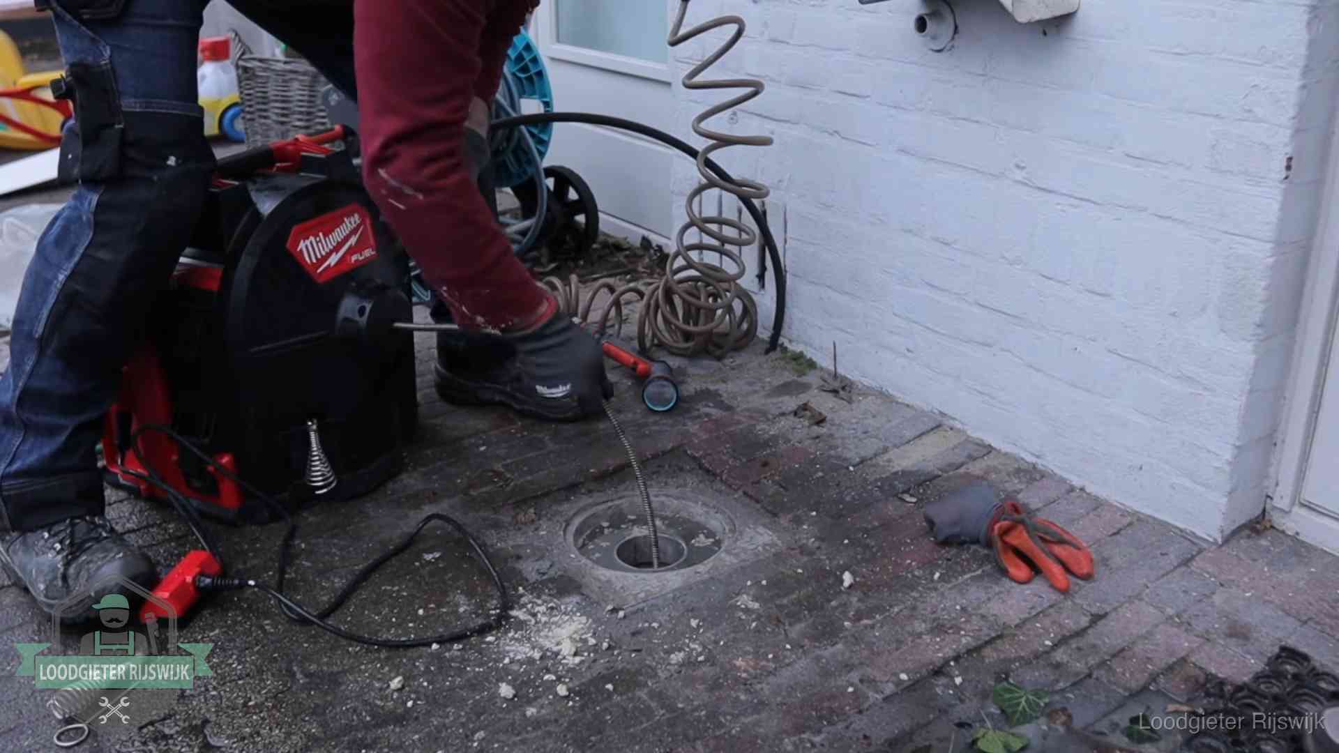 Prijs van een rioolontstopping in Rijswijk Spiraalmachine bij een ontstoppingsputje in de bestrating in Rijswijk