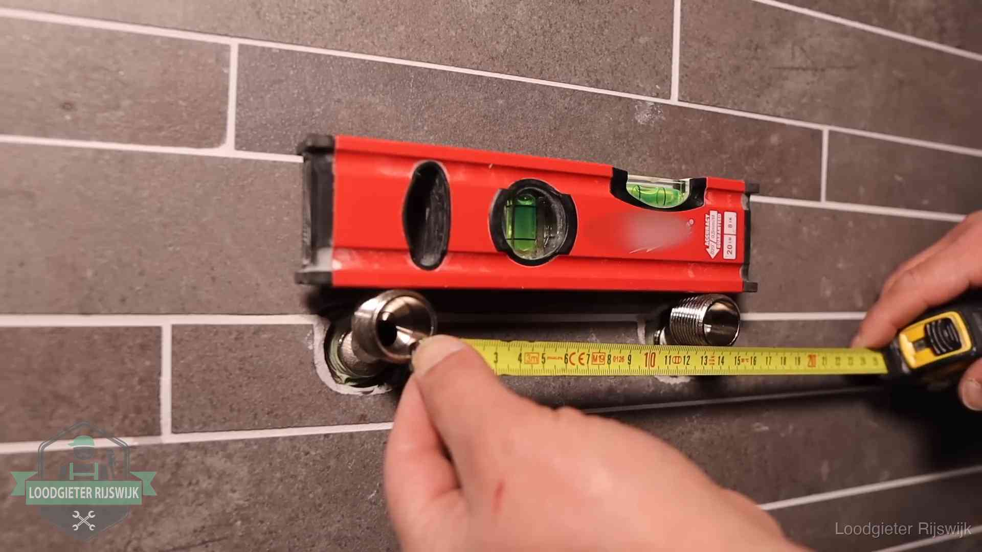 Waterpas en duimstok bij kraan-aansluitpunten in een badkamer in Rijswijk