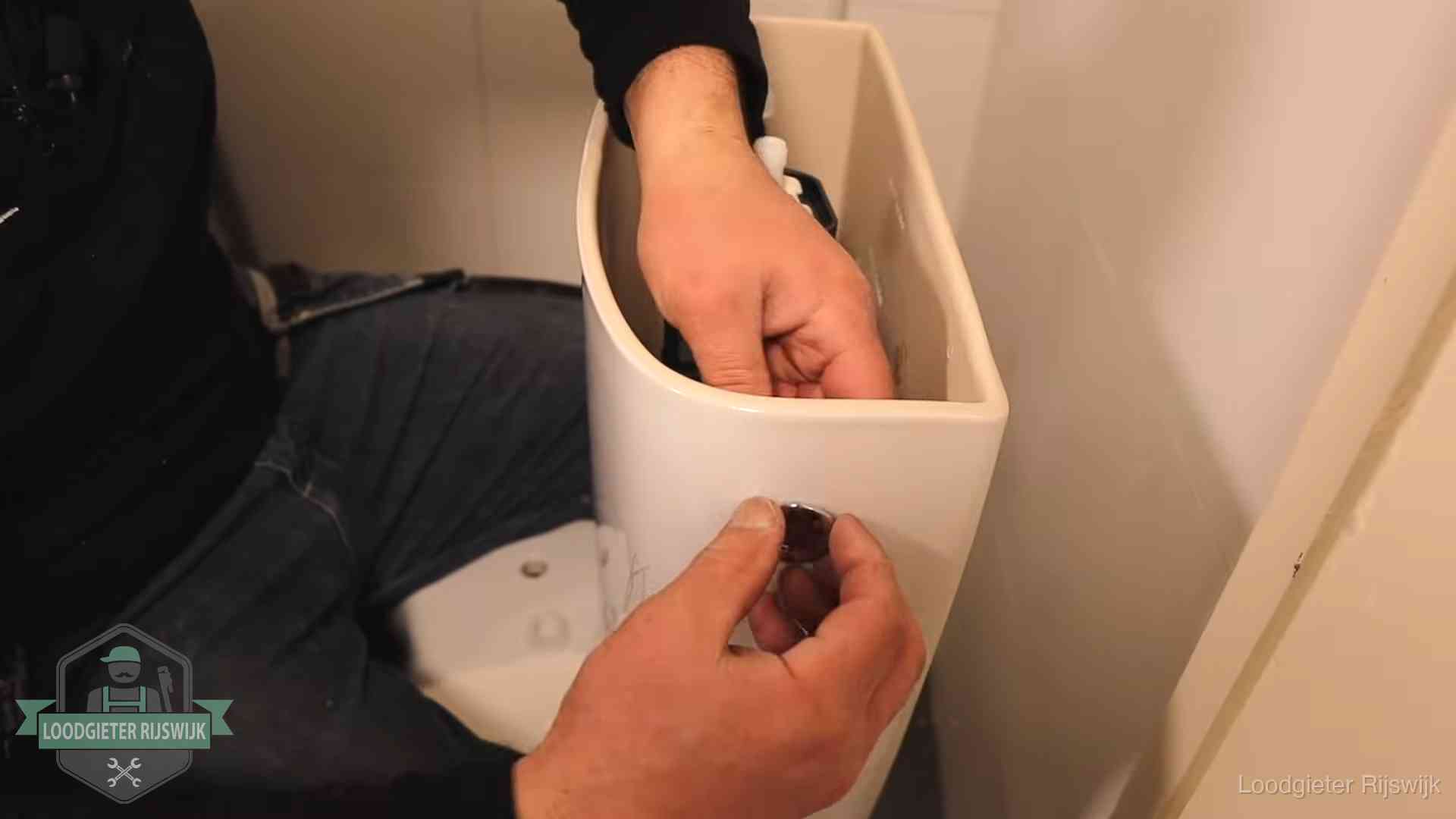 Je wc verstoppingsvrij houden in Rijswijk Drukknop van een duoblok-stortbak wordt gemonteerd bij een toilet in Rijswijk